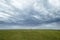 Person walking on the horizon with dark dramatic sky behind.