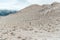 Person walking on path on rocky terrain, arid landscape. Island Pag, Croatia.