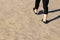 Person walking on sandy surface laving footprints behind