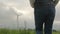 Person walks on grass looking at functioning windmill