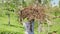 Person walks holding large wood pile over head slow