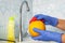 Person washes fruit with eco soap for washing in a kitchen with blue walls. Decontamination and disinfection of products from