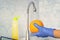 Person washes fruit with eco soap for washing in a kitchen with blue walls. Decontamination and disinfection of products from