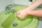 A person washes well-soaped hands under a tap with water