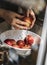 A person washing pomegranate under running water food photography idea