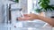 A person washing their hands in a sink with running water, AI