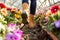person wearing boots stepping into a flower greenhouse