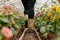 person wearing boots stepping into a flower greenhouse