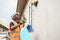 Person wearing an orange safety vest is engaging in home repair work