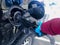 A person wearing single use gloves, pumping gasoline to a chevrolet SUV vehicle during the