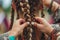 person weaving intricate braids for a festival look