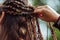 person weaving intricate braids for a festival look