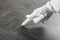 Person in white glove checking cleanliness of stone table, closeup