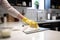 person, wiping down kitchen counter with disinfectant wipes