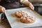 Person woman hands holding Freshly baked tasty pies at baking sheet pan at wooden table in bakery house baking and kitchen utensil