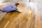 Person working  rubbing oiling with linseed oil natural wooden kitchen countertop before using. Solid wood butcher block.