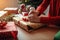 person, wrapping presents on christmas morning, with view of festive living room visible in the background