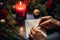 A person writing on a piece of paper next to a christmas tree