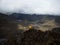 Person in yellow jacket infront of Andes hills tundra grassland lakes landscape in El Cajas National Park Cuenca Ecuador