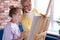 Personal art teacher teach little girl to draw on easel