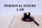 Personal Injury Law written on the wall with gavel on wooden background. Law concept