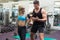 Personal trainer coaching female bodybuilder lifting dumbbell