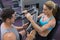 Personal trainer coaching female bodybuilder using weight machine