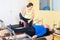 Personal trainer controlling movements of mature man doing pilates on reformer in fitness studio