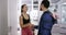 Personal trainer or fitness coach and a fit, healthy woman share a handshake in his office at the gym or sports club