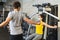 Personal trainer helping young female athlete in the gym while both of them wearing protective face masks