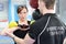 Personal trainer helping young woman with kettle bells