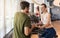 Personal trainer setting the timer of the stationary bicycle for his client