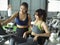 Personal trainer supporting and helping young female to exercise on treadmill cycling