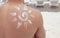 Persons back with sunscreen picture of sun on it, protect skin from damage