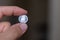 Persons hand holding out a dime coin or ten cents, the Currency of the Canada -  on a brown background. Money exchange