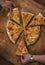 Persons take pieces of baked homemade cheese pie on wooden background. Bulgarian banitsa, Georgian khachapuri,