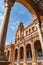 Perspective of blurred column with arch framing palace tower in Plaza de España, Seville SPAIN