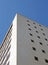 Perspective corner view of an old white 1960s concrete office block against a blue sky