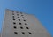 Perspective corner view of an old white 1960s concrete office block against a blue sky