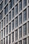 Perspective detail of tall high rise modern apartment building with geometric white cladding and dark windows