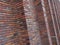 Perspective diagonal view on abstract brown red brick wall with columns with blured background. Architecture element brown brick w
