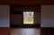 A perspective from inside a traditional Japanese tatami room with view of fiery maple trees in a Japanese garden