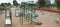 Perspective/panoramic view of a public outdoor children`s playground with wood chips on ground in a suburban neighbourhood