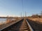 Perspective of rounded rails. Railway track turns and twists between out of focus hills background. Empty rounding and turning