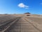 Perspective of sand rutted road in desert and volcanic landscape. Background of raked white sand. Clean beach sand texture with