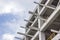 Perspective shot of construction of a new reinforced concrete and metal beams linked building with open blue sky