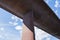 Perspective from under a huge, concrete bridge against summer sky