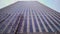 Perspective and underside angle view to textured background of modern glass blue building skyscrapers in the evening