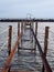 Perspective view of an abandoned broken rusty iron jetty running into to sea