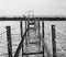 Perspective view of an abandoned broken rusty iron jetty running into to sea